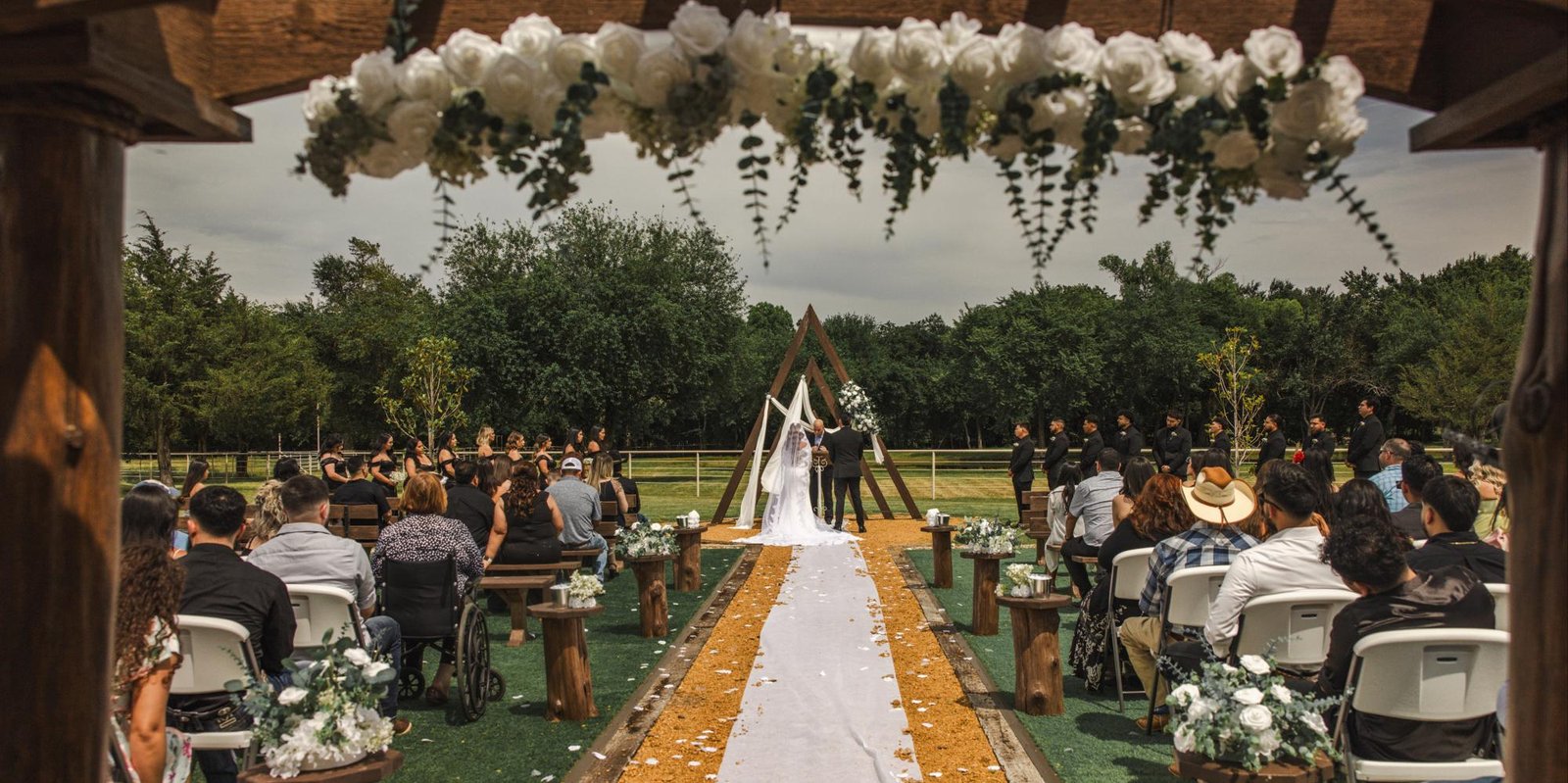 Outdoor ceremony area with rustic benches and green turf at dream ranch event venue located in dfw area