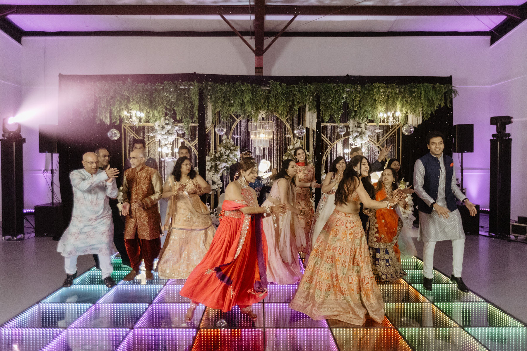 packed wedding dance floor with guests dancing and celebrating at Texas ranch venue